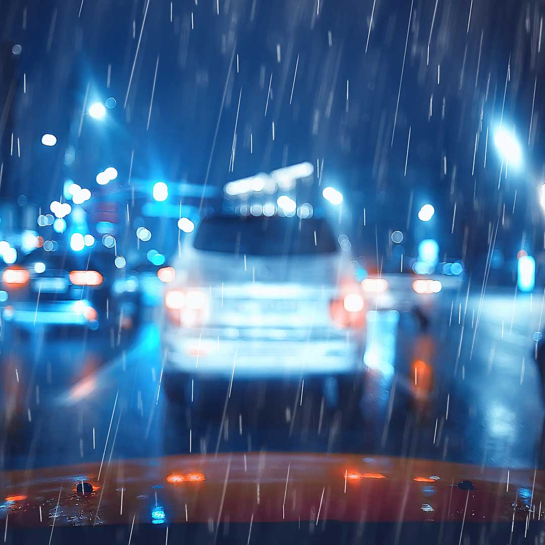 Blendende Lichter bei Autofahrt im Regen